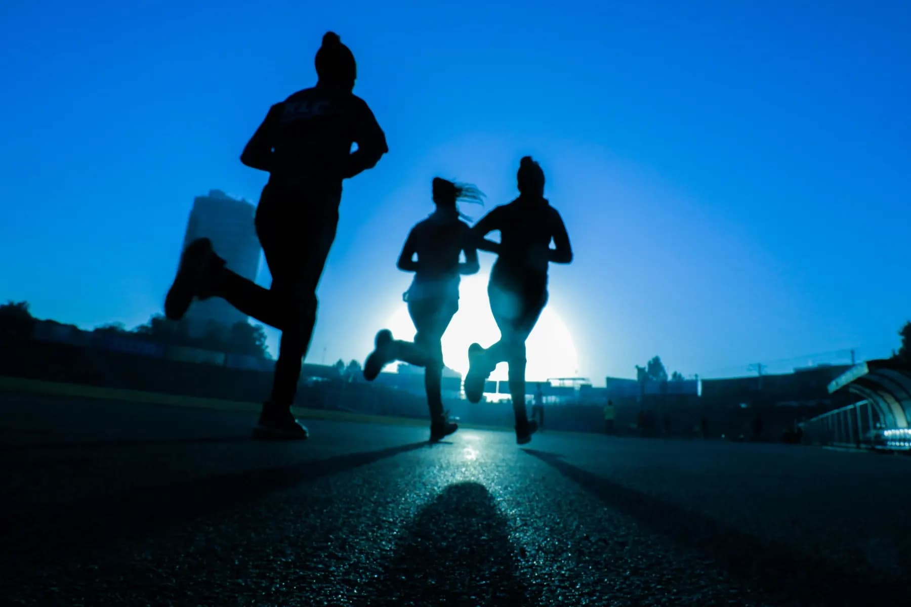 Tres corredores del club entrenando juntos al amanecer